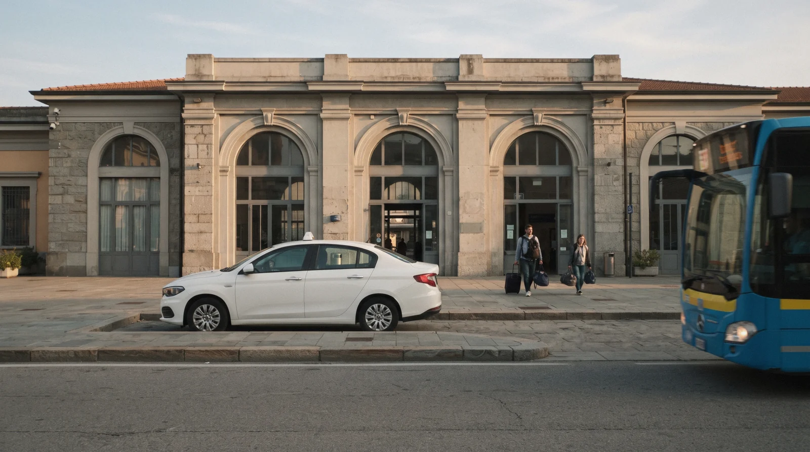 A white taxi waiting outside Como San Giovanni station in the late afternoon, the Como taxi rank