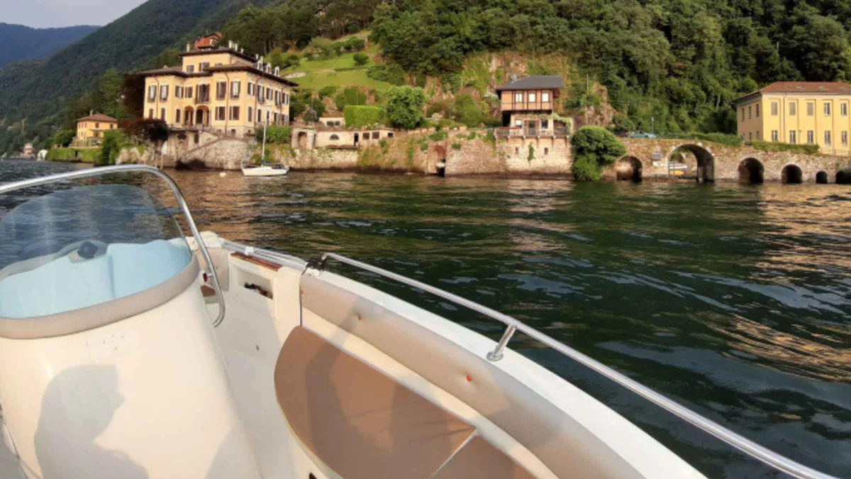 A rented motorboat anchored near a villa dock on a 3-hour boat rental in Como, Italy