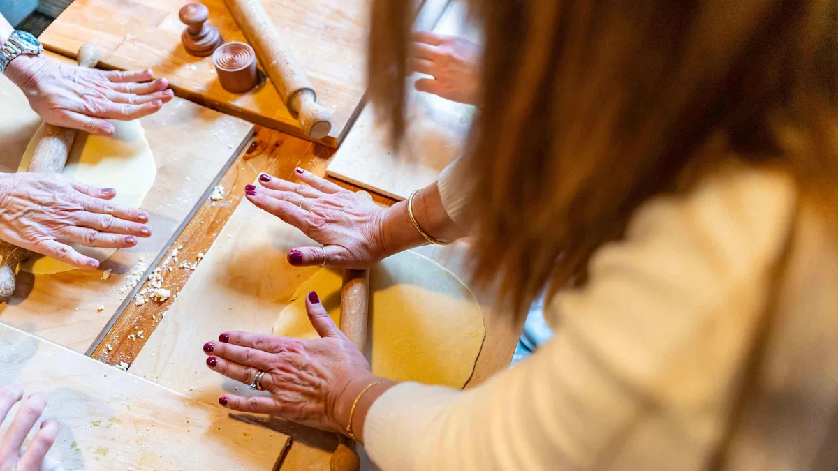 A home kitchen table set with fresh pasta and tiramisu on a Como cooking class in Como, Italy